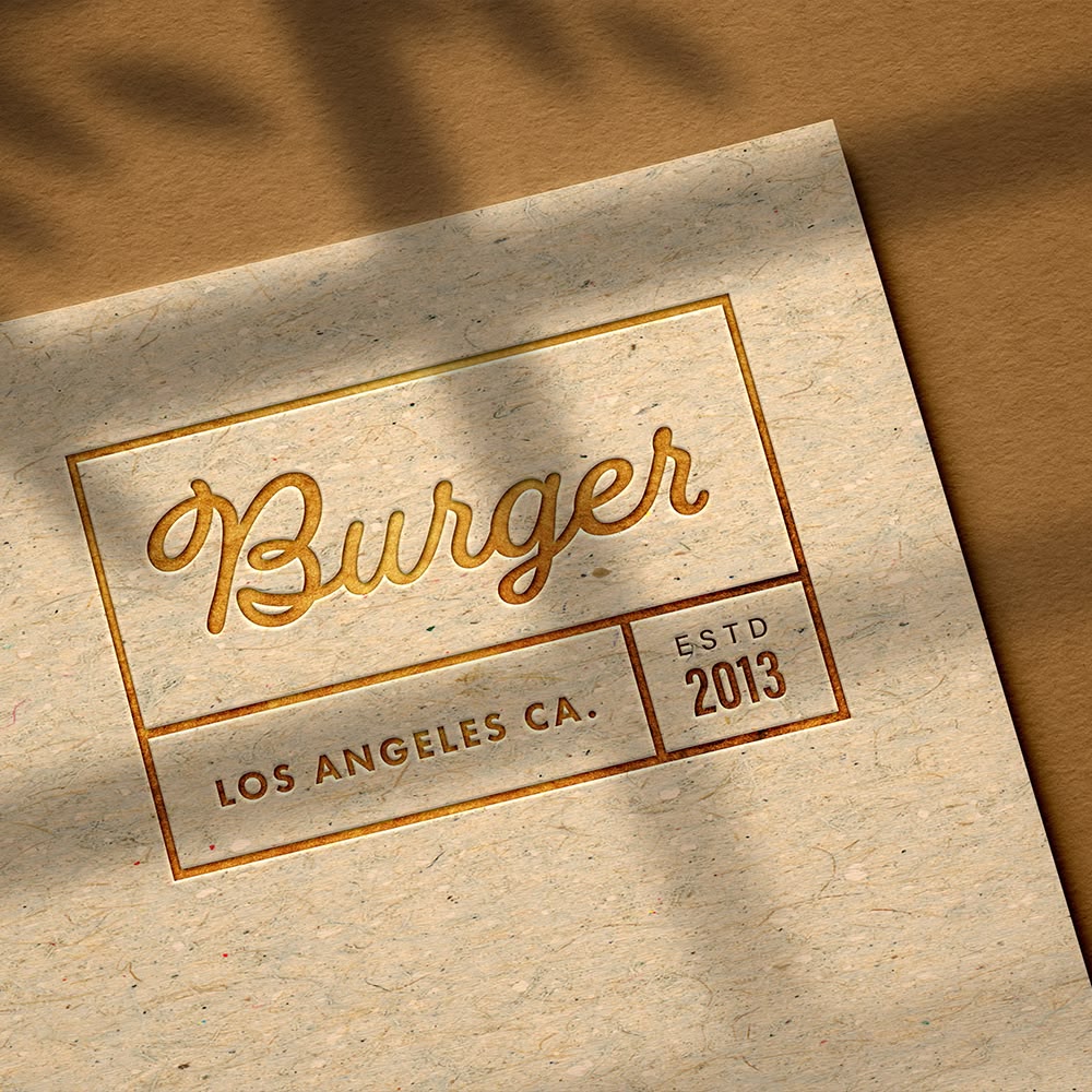Embossed restaurant logo reading Burger, Los Angeles CA, on kraft paper